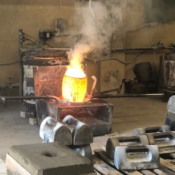 The crucible in the foundry is filled with molten brass so they can pour into the sand molds